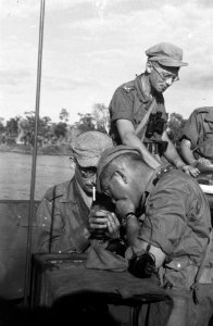 Militairen roken sigaretten in een landingsvaartuig, Bestanddeelnr 2372