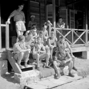 Militairen met een aapje op de trap van een van de verbliven in kamp Morib beach, Bestanddeelnr 255-8286