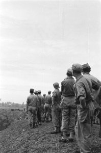 Militairen kijken hoe in de verte een Dakota opstijgt, Bestanddeelnr 208-1-4