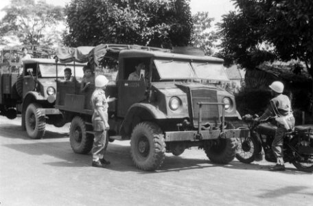 Militaire politieman controleert papieren van een legertruck, Bestanddeelnr 7284