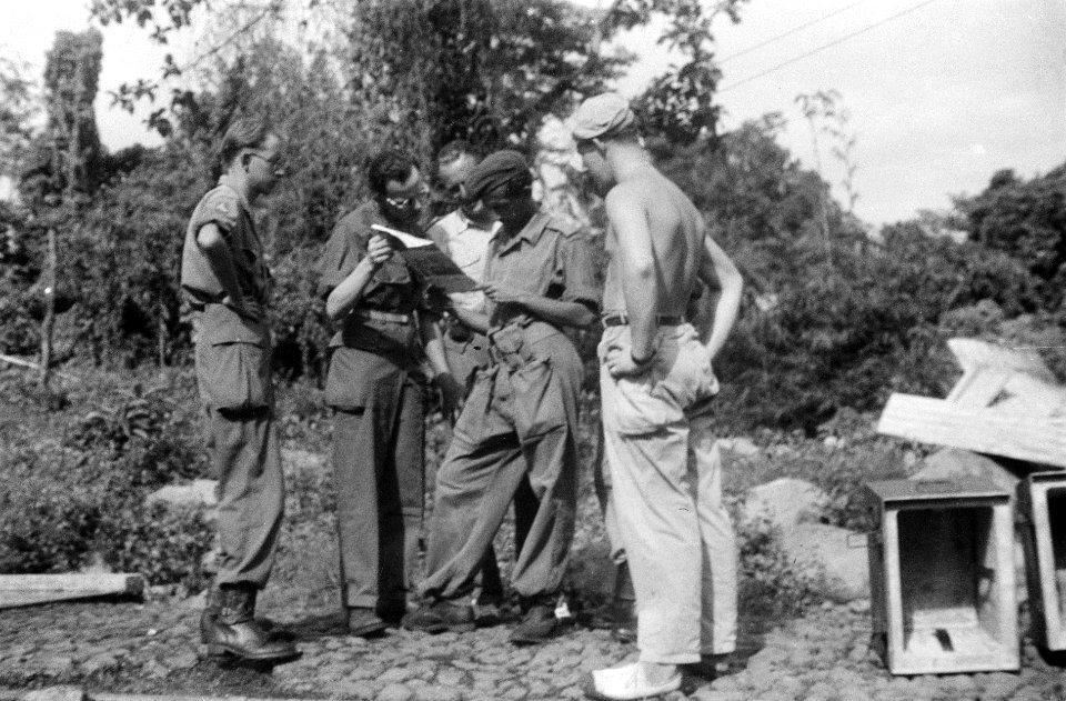 Militairen en mannen in uniform bekijken een blad papier, Bestanddeelnr 6699