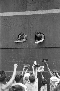 Militairen gooien uit de patrijspoort sigaretten voor de kinderen op de kade, Bestanddeelnr 91-2-4