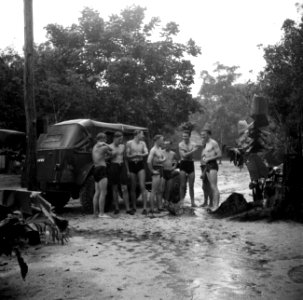 Militairen in zwembroek in de regen bij hun kampement bij Zanderij in Suriname, Bestanddeelnr 252-6399