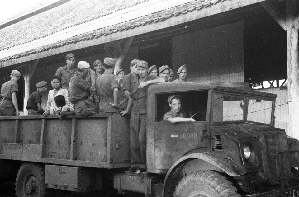 Militairen in de laadbak van een drietonner. Er is ook een jonge vrouw met kind, Bestanddeelnr 1625-5-1