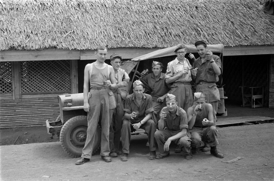 Militairen met glazen in de handen poseren voor een jeep, Bestanddeelnr 86-4-5