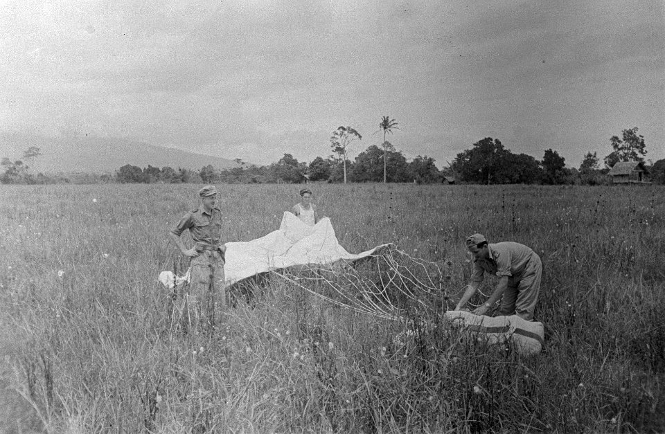 Militairen van een buitenpost bij een baal per parachute gedropt, Bestanddeelnr 3089