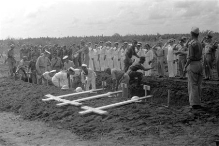 Militairen van land- en zeemacht plaatsen de kisten in de groeve, Bestanddeelnr 104-4-3
