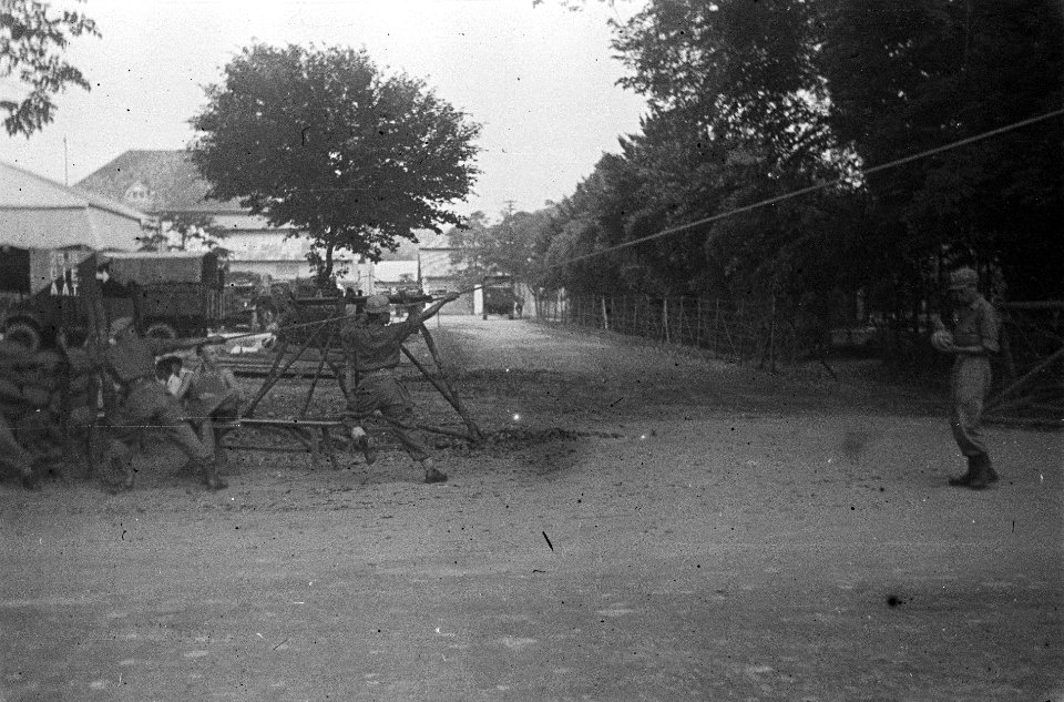 Militairen trekken aan een touw of kabel vlakbij de ingang van een kazerne of l…, Bestanddeelnr 5864