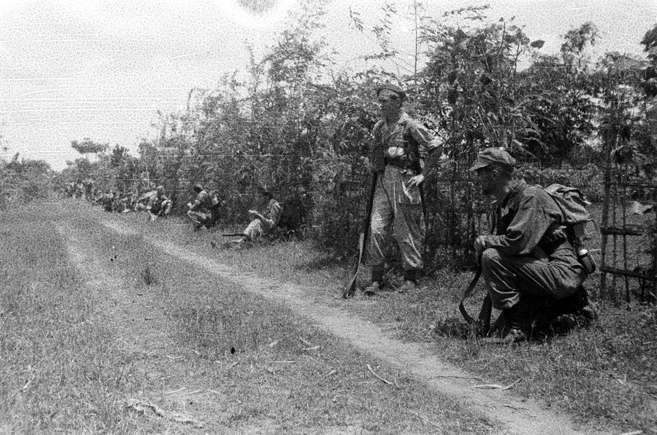 Militairen tijdens een rustpauze langs het karrepad. Men blijft waakzaam, Bestanddeelnr 5097