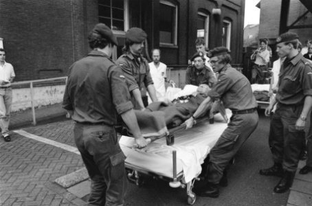 Militairen verplaatsen een patiënt op een brancard en een bed, Bestanddeelnr 934-4804