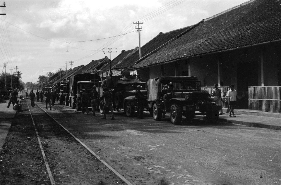 Militaire colonne houdt halt op straat in dorp of stad met links spoor- of tramr, Bestanddeelnr 3219