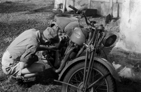 Militair bezig met het onderhoud van zijn motorfiets, Bestanddeelnr 2845