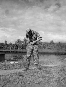 Militair in camouflage uniform kijkt naar zijn middel, Bestanddeelnr 8508