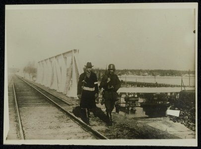 Militair en burger bewaken een brug, Bestanddeelnr 158-0347