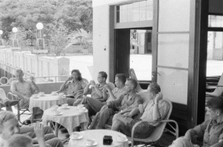 Militairen en een vrouwelijke militair zitten op een terras, Bestanddeelnr 382-4-3