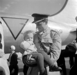 Militair met een kind in de armen voor een vliegtuig, Bestanddeelnr 254-5375
