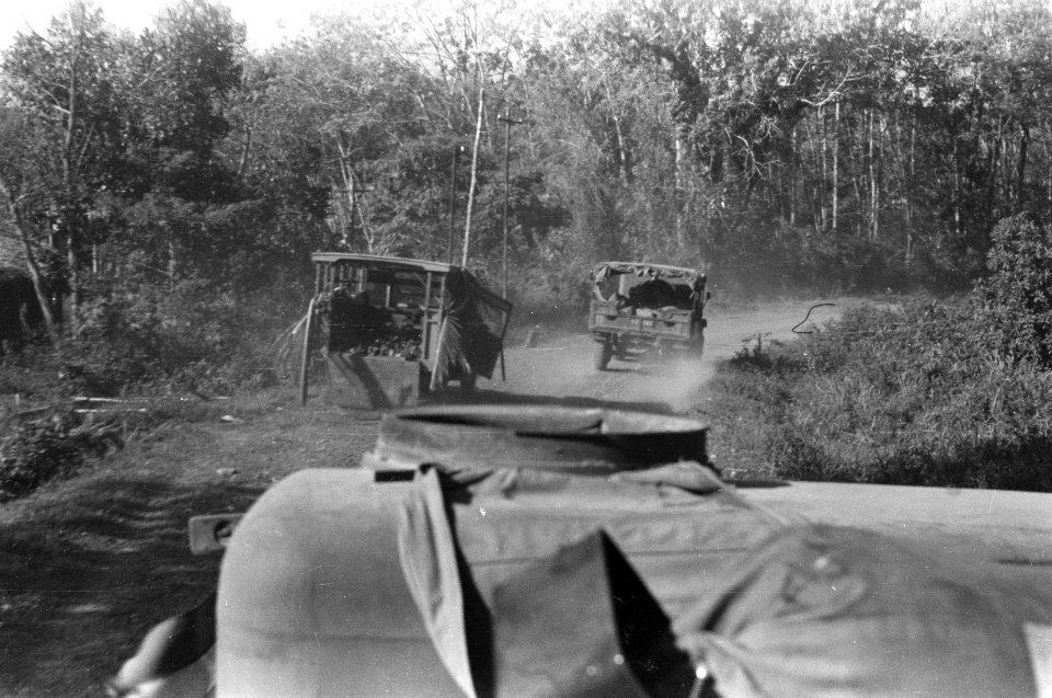 Militaire colonne passeert een verwoeste truck die langs de kant van de weg staa, Bestanddeelnr 321-4-2