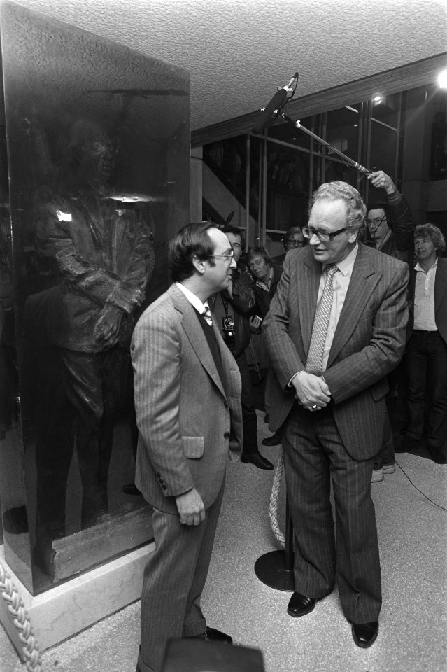 Minister Van Kemenade (PvdA, rechts) in gesprek met de zoon van de componist Ron, Bestanddeelnr 931-7874