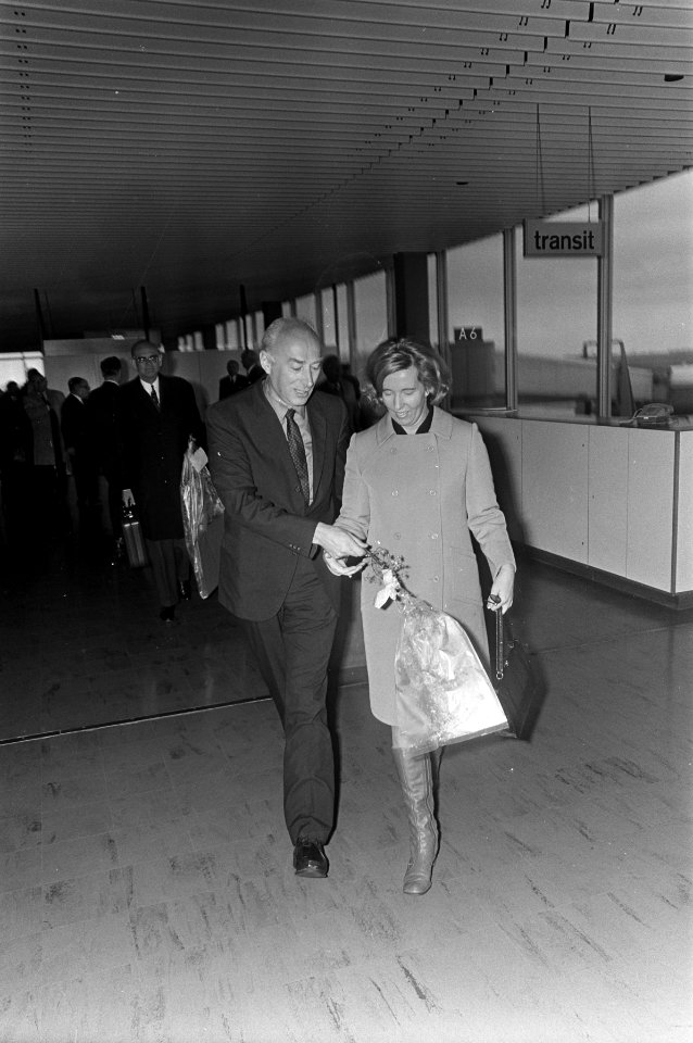 Minister T.A. Bakker terug uit de West op Schiphol geeft bloemen aan echtgenote, Bestanddeelnr 922-0188