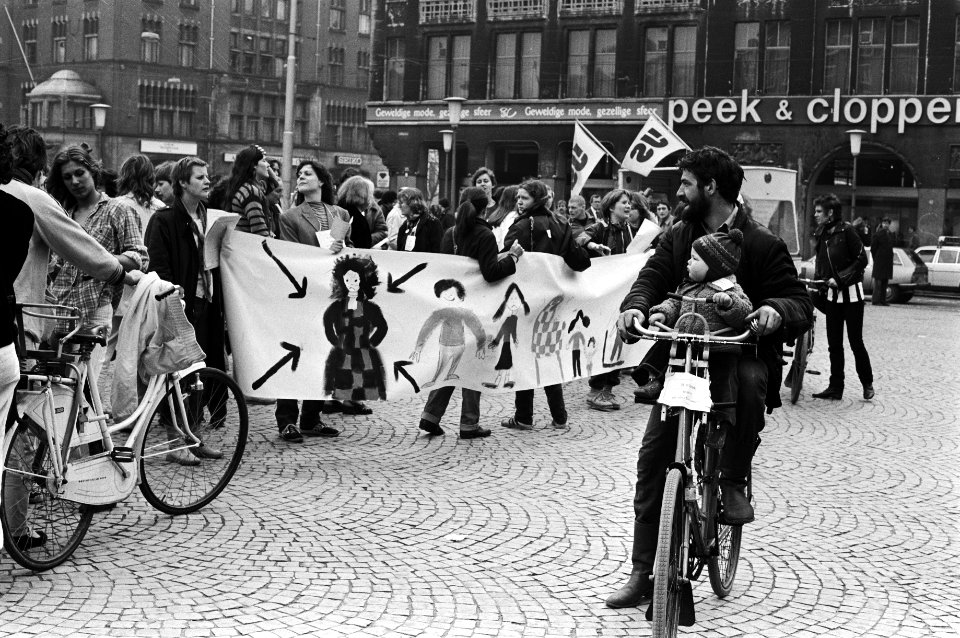 Nationale vrouwenstakingsdag, vader met kind kijken naar voorbijtrekkende demonstrerende vrouwen op de Dam, Bestanddeelnr 931-4050