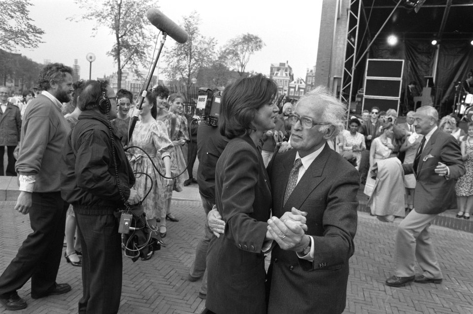 Nationale viering Bevrijding in Amsterdam dr. Lou de Jong danst buiten op muzie, Bestanddeelnr 934-2437