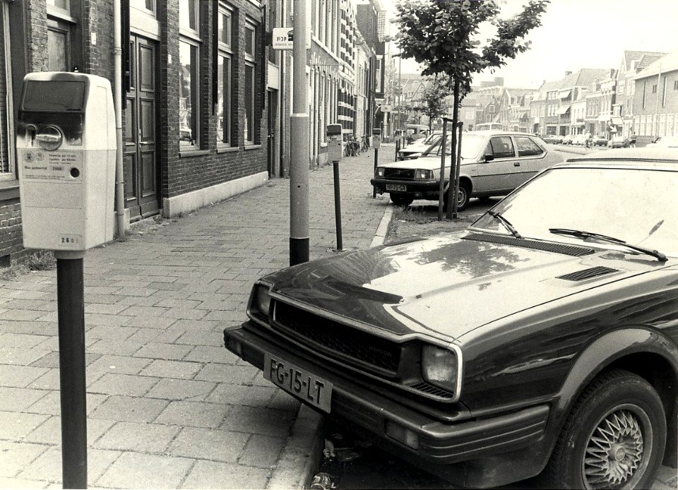 Nassaulaan, ziende naar het zuiden, zwart gespoten parkeermeters. Geschonken in 1986 door United Photos de Boer bv. - Gepubliceerd in het Haarlems Dagblad van 16-07-1983. Identificatienummer 54-016763