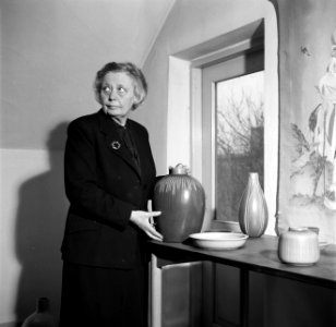 Nathalie Krebs staand bij een tafel met diverse keramieken vazen en schalen, Bestanddeelnr 252-8891
