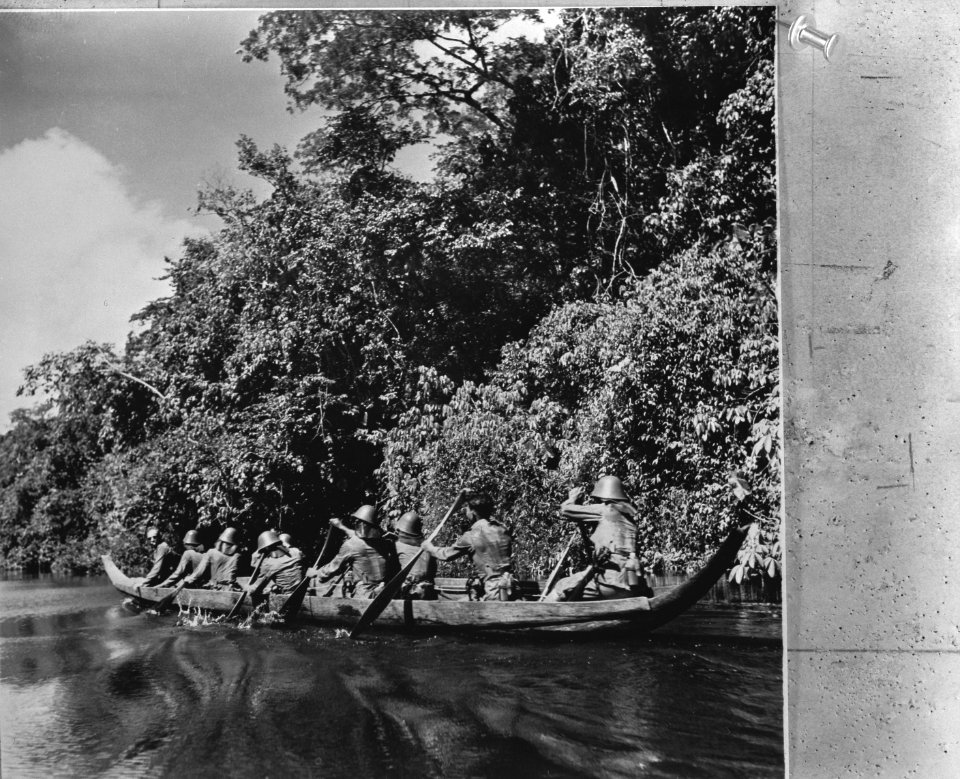 Nederlandse KNIL-militairen peddelen met een prauw over een rivier, Bestanddeelnr 935-1572