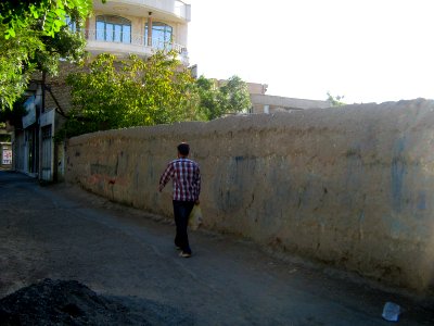 Mud wall - man taking his buy to home - morning - walking - 17 st - Nishapur photo