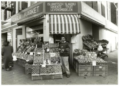 Muammer Ilgen bij zijn groente- en fruitwinkel. NL-HlmNHA 54035322