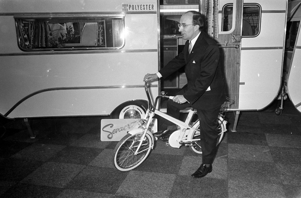 Mr. J. Cals opende caravan-tentoonstelling, hier op een vouwfiets in de RAI, Bestanddeelnr 920-0207