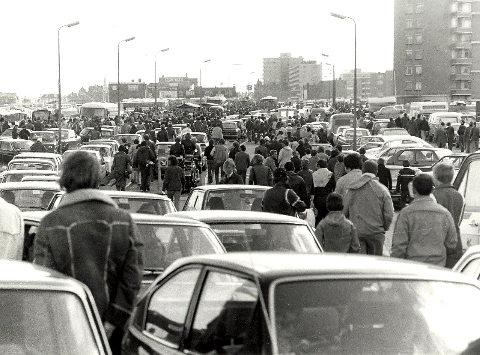 Na afloop van de autoraces keert het publiek huiswaarts, de drukte op de Burgemeester van Alphenstraat, ziende naar het zuiden. Aangekocht in 1982 van fotograaf C. de Boer. - Negatiefnummer , NL-HlmNHA 1478 25900 K 38