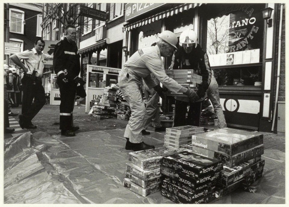 Ná het blussen van de brand in speelgoedwinkel Intertoys worden dozen vol speelgoed naar buiten gedragen. NL-HlmNHA 54031505