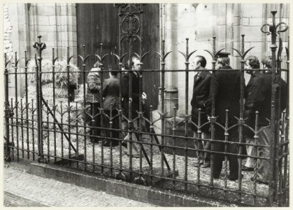 Na het ontploffen van een nep-bom worden de strobalen bij de kerk opgeruimd. NL-HlmNHA 54005121