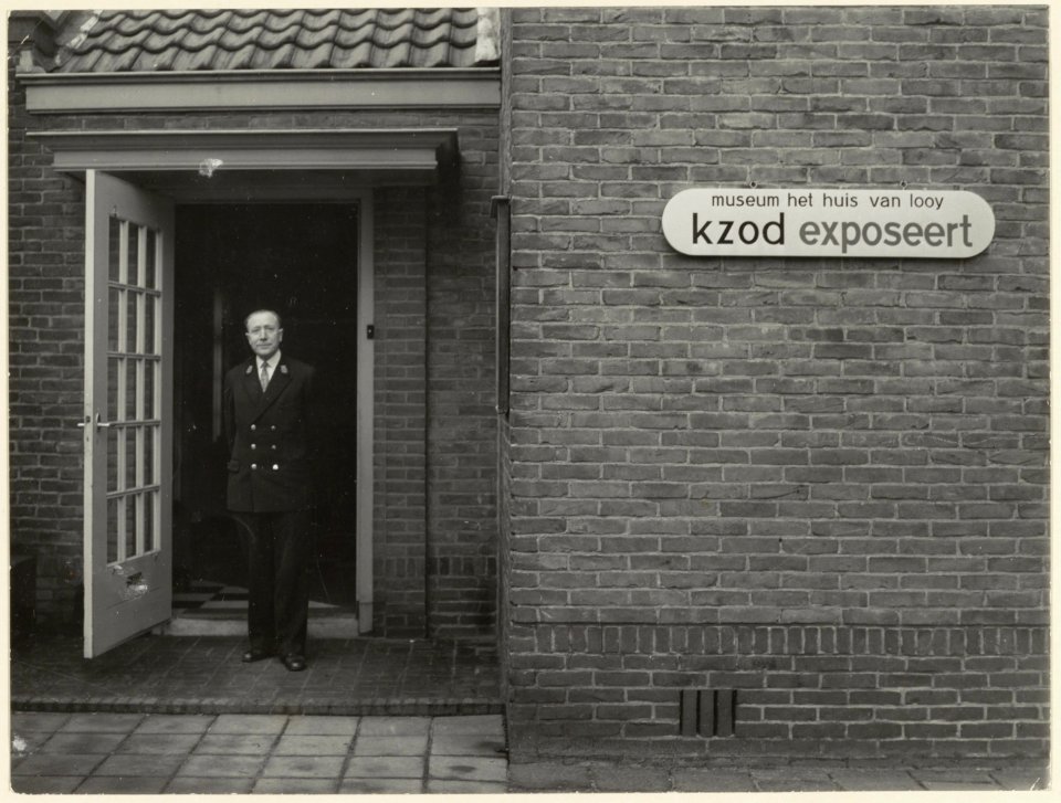 Museum Het Huis van Looy aan de Kleine Houtweg 103 ingang Kamperlaan ten tijde van een door het K.Z.O.D gehouden expositie. Naam persoon onbekend. NL-HlmNHA 54004429
