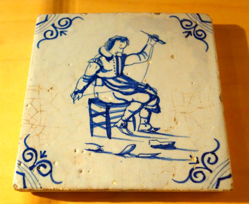Netherlands tile depicting shoemaker stitching footware, 1 of 2, c. 1630, ceramic - Bata Shoe Museum - DSC00291