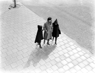 Nell Langlais loopt met haar dochters Renée (links) en Hans in de regen over str, Bestanddeelnr 252-0479 photo
