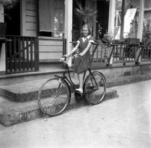 Nettie Boogh op haar fiets voor haar huis in Paramaribo, Bestanddeelnr 252-6899