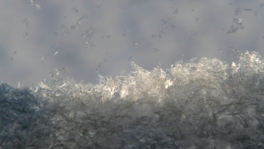 Newly fallen snow crystals accumulating on a window sill
