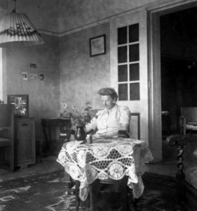 Nederlandse vrouw zit in stoel bij salontafel in een woonkamer, Bestanddeelnr 13011