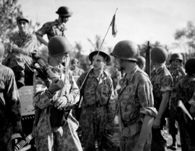Nederlandse militairen in camouflagepakken overleggen. De soldaat links draagt …, Bestanddeelnr 10530