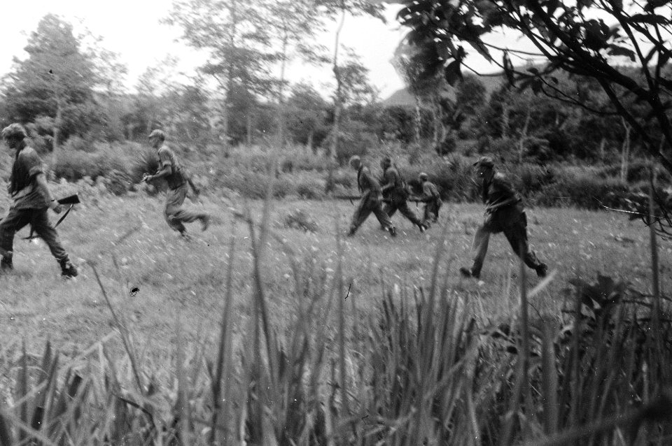 Nederlandse militairen rennen over een open veld met wapens in de aanslag, Bestanddeelnr 2748