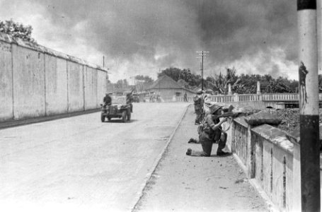 Nederlandse militairen in positie langs een balustrade langs een boulevard. Een , Bestanddeelnr 5724