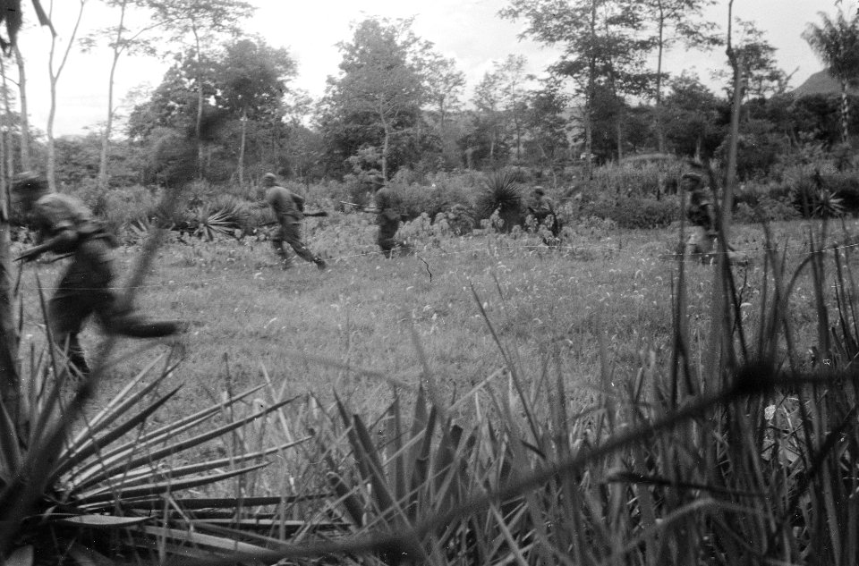 Nederlandse militairen rennen over een open veld met wapens in de aanslag, Bestanddeelnr 2749