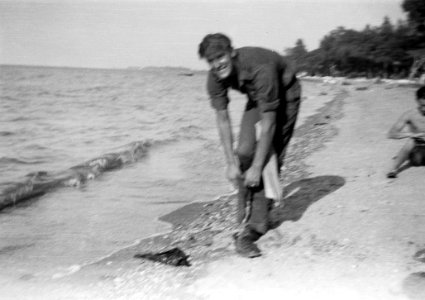 Nederlandse militair trekt zijn kleding weer aan op een strand, Bestanddeelnr 8347