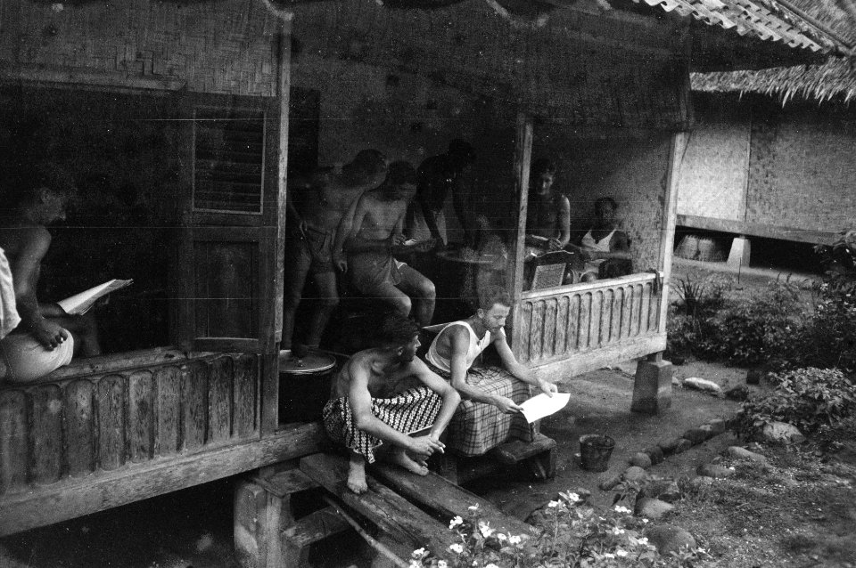 Nederlandse militairen, deels gekleed in sarongs, ontspannen op een veranda van , Bestanddeelnr 2600