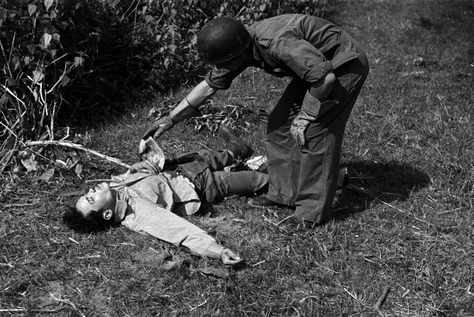 Nederlandse militair buigt zich over lijk van een Republikeinse streider en tilt, Bestanddeelnr 7549
