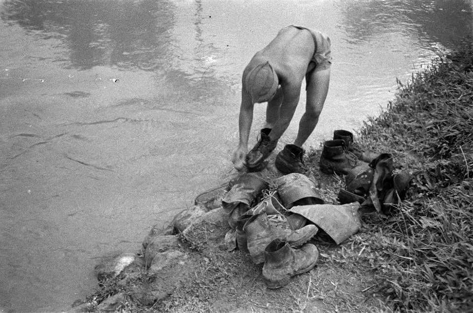 Nederlandse militair wast laarzen in een rivier, Bestanddeelnr 3559