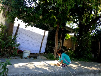 Niña fabricando escoba espiga