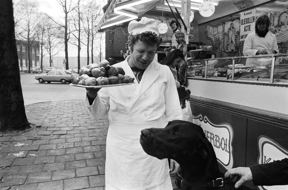 Oliebollenverkoop in Amsterdam gestart bakker biedt hond oliebol aan, Bestanddeelnr 930-0590